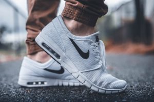 Floor side view of white nike sneakers
